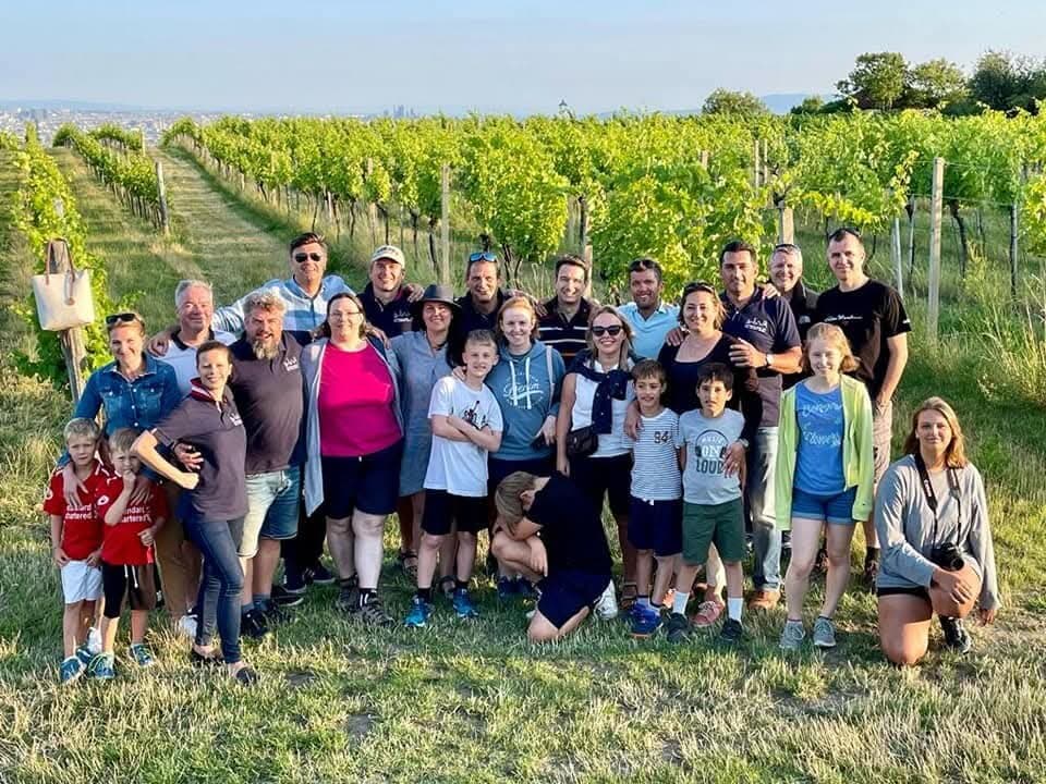 About thirty of us, kids included, in a vineyard on a summer evening, a city spread out on the plain behind
