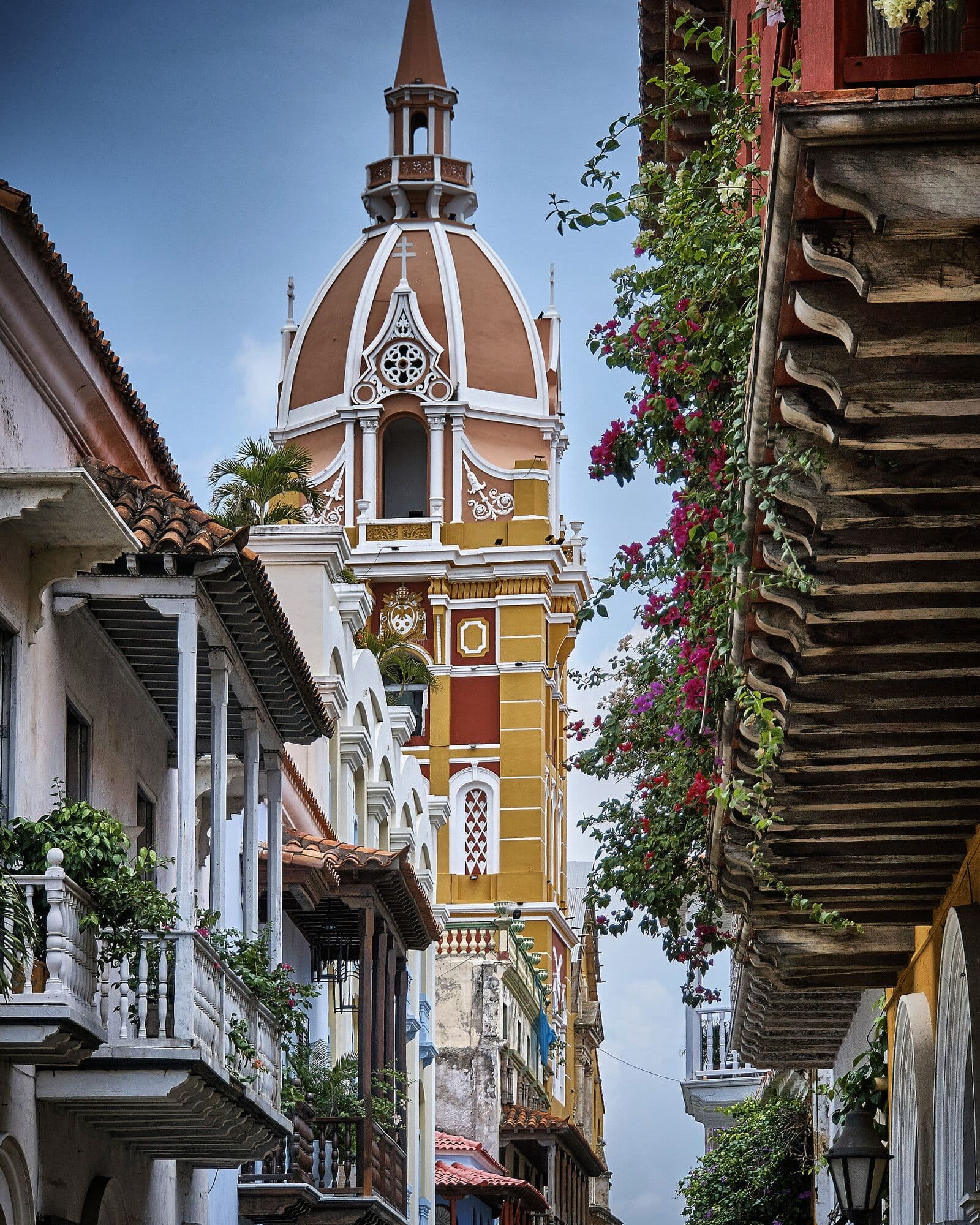 A narrow street of balconies and flowers leading to the cathedral tower
