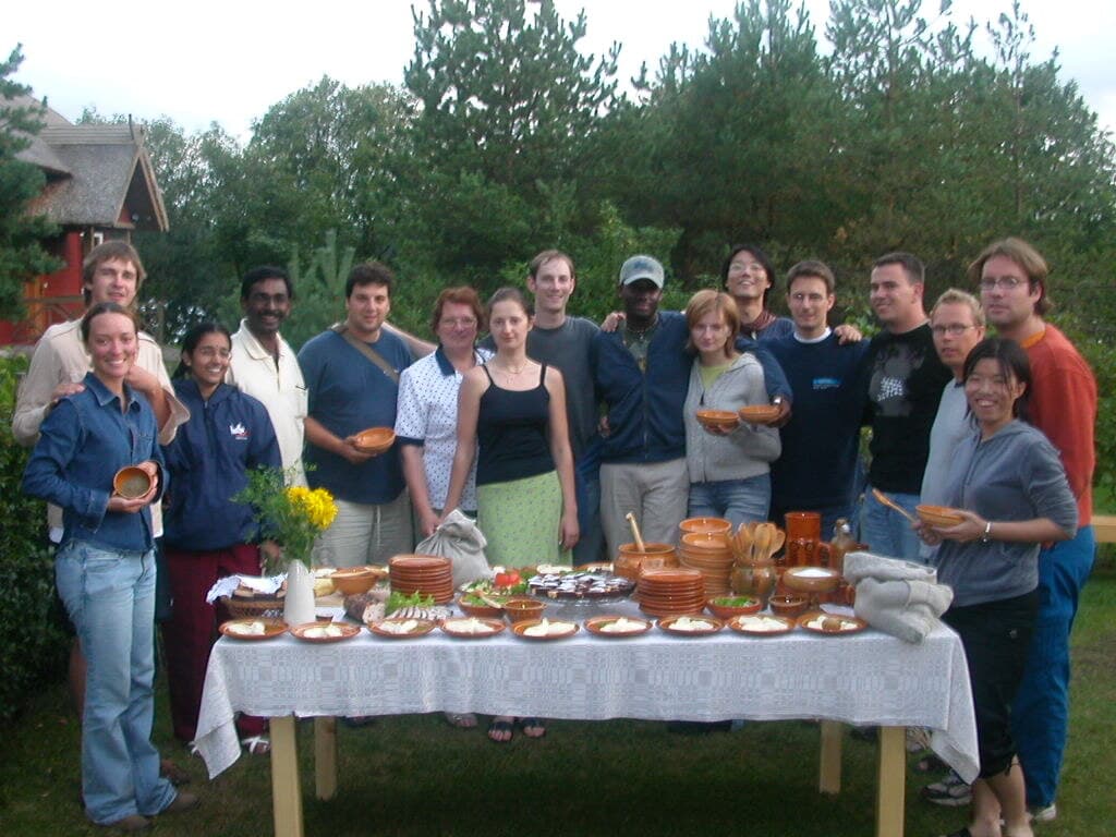 About sixteen of us around a garden table laid with clay bowls, a thatched house behind