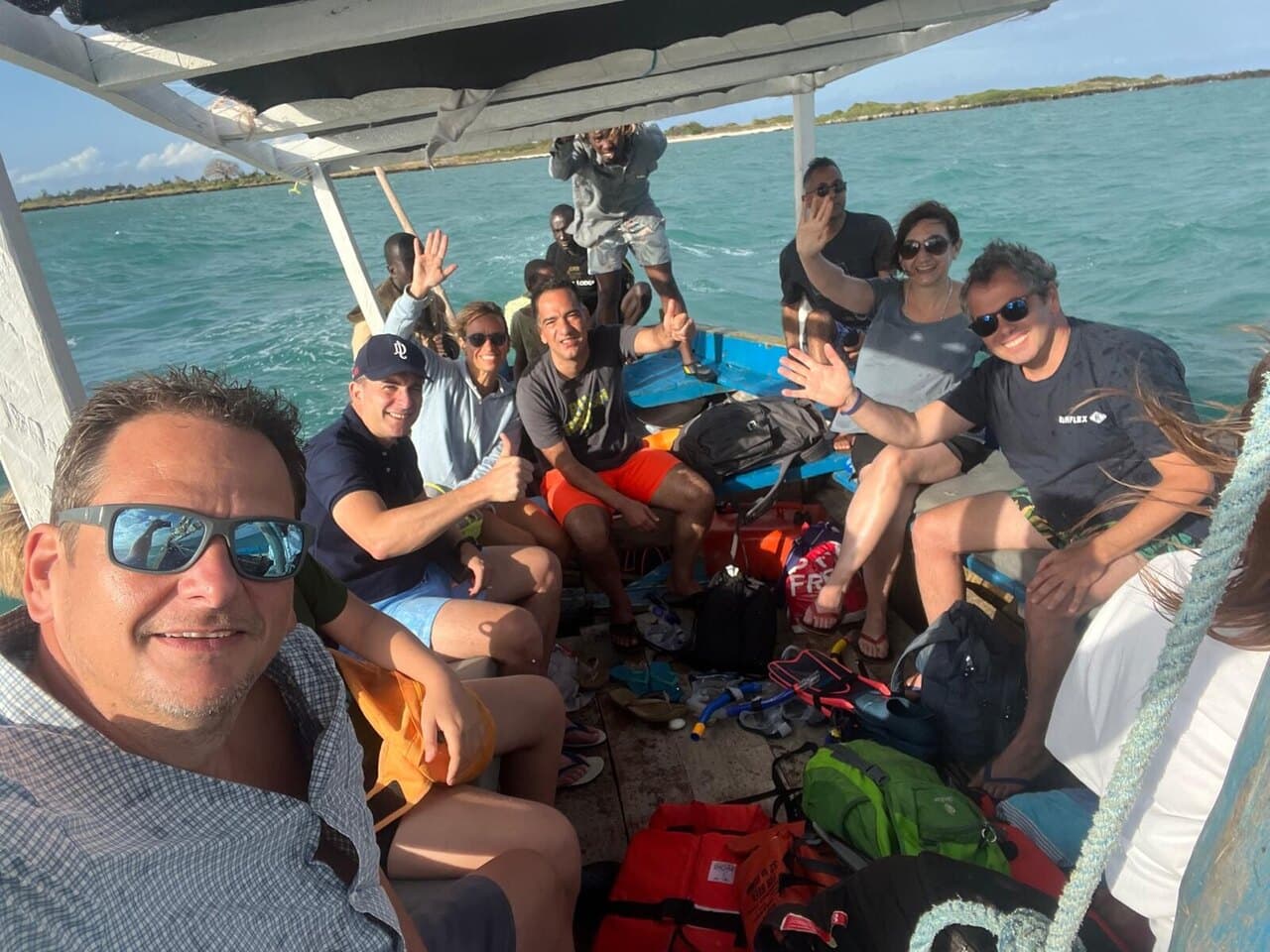 A dhow full of us waving at the camera, bags and life jackets at our feet