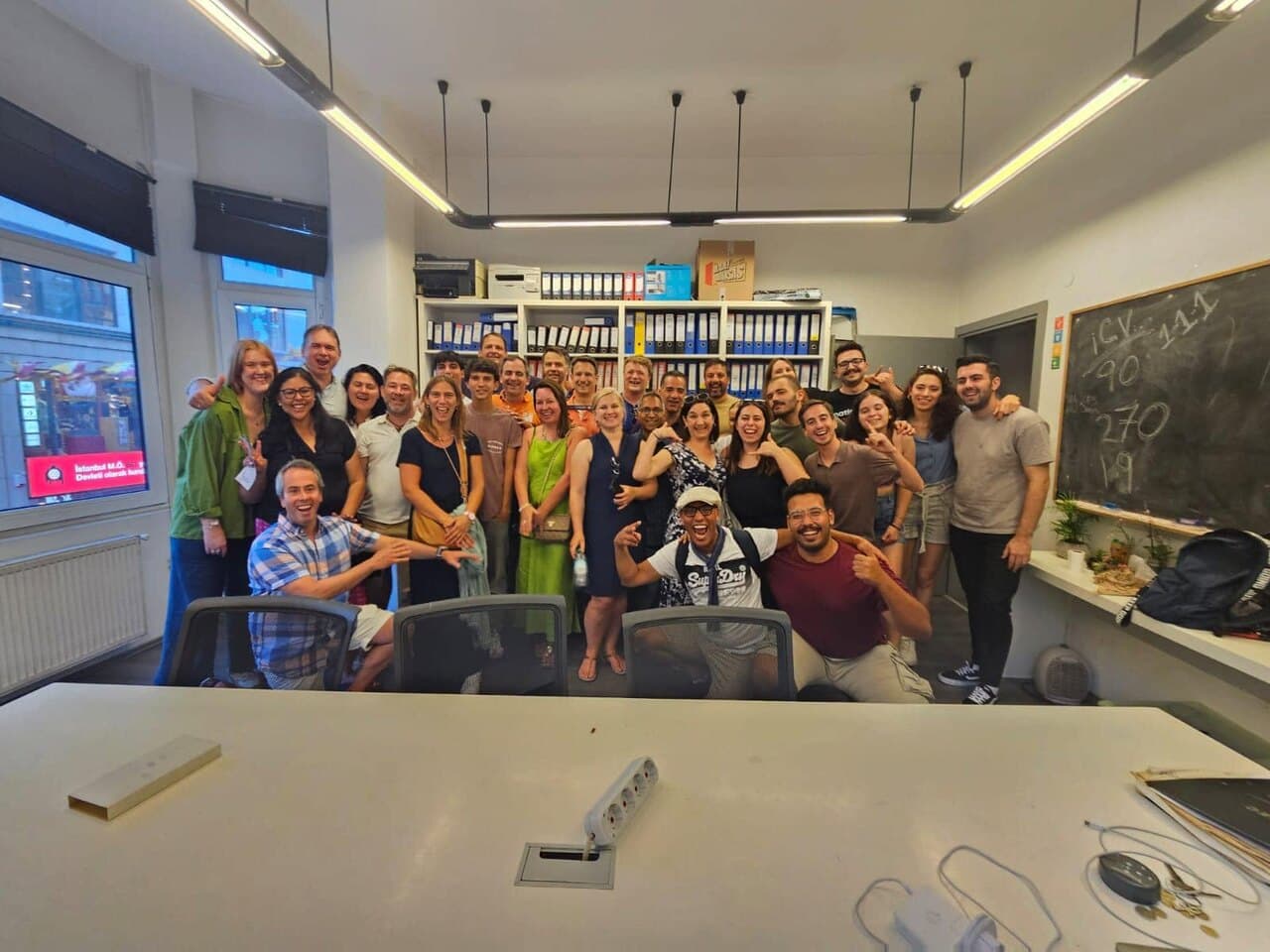 About forty of us crowded into an office, grinning and pointing at the camera